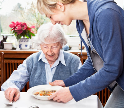 A caregiver helping an older adult with a meal